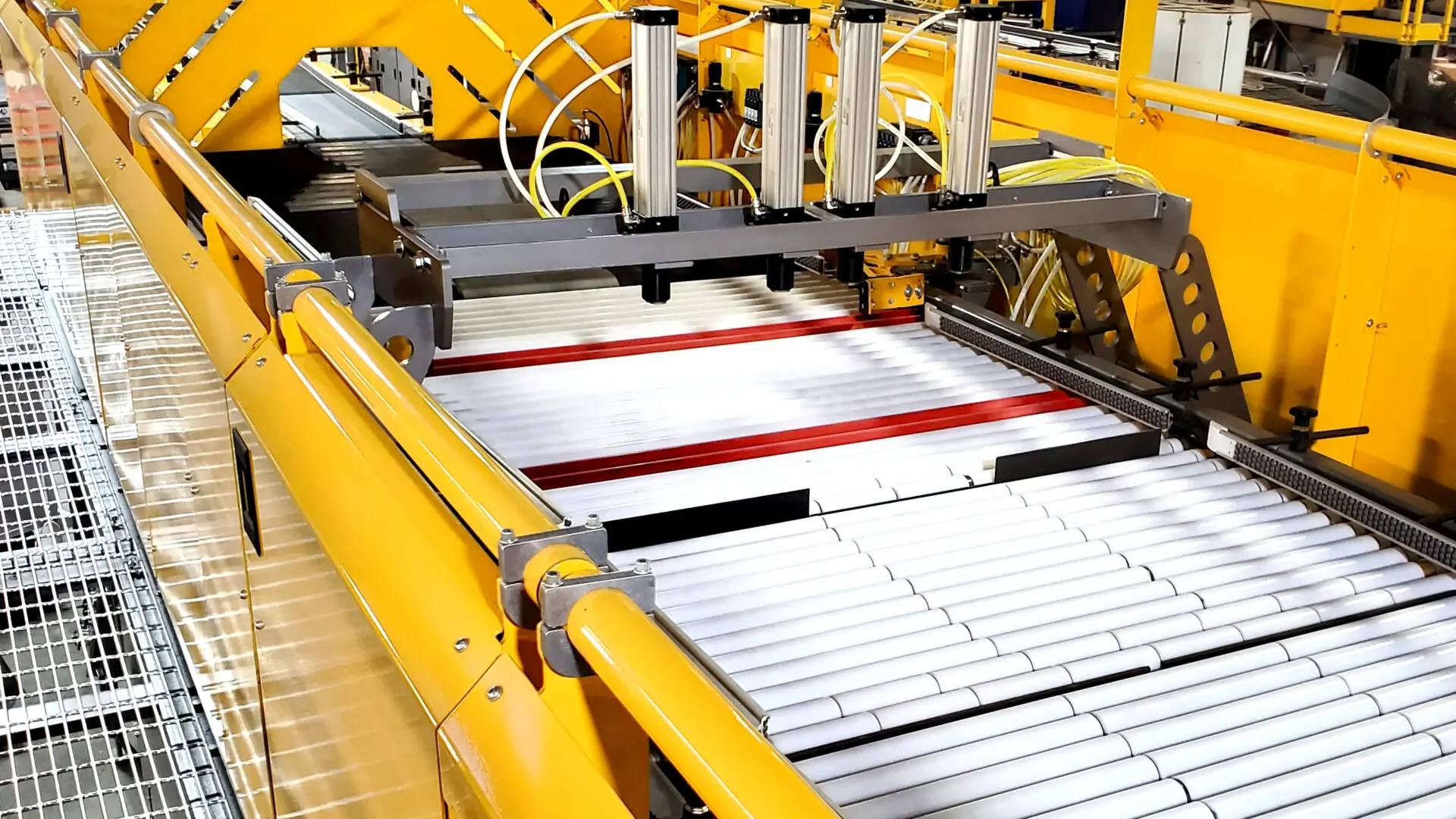 A conveyor belt with four metal rollers on it.