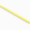 A yellow stick of wax is laying on the ground.